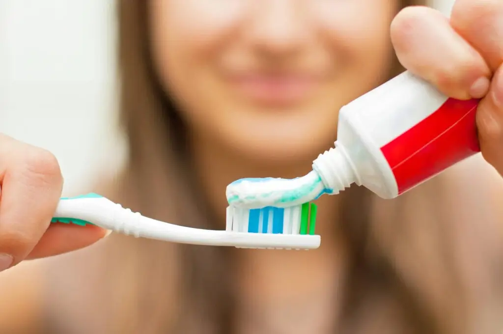 patient brushing teeth after auburn teeth whitening treatment